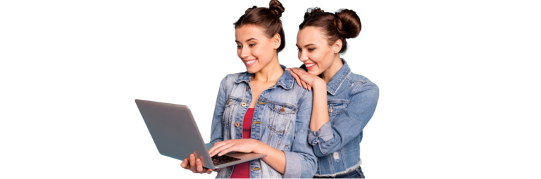 Zwei Frauen lächeln während sie auf den Laptop schauen.