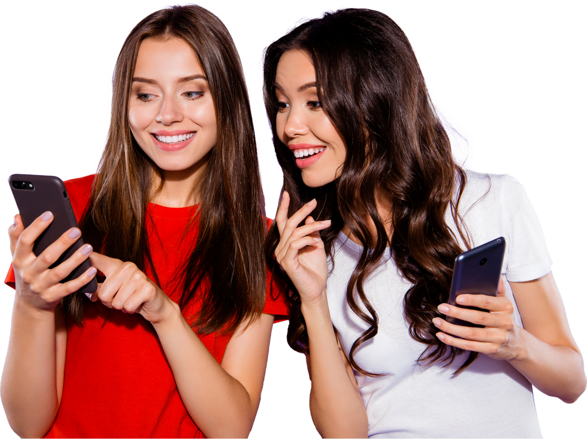 AKTION Zwei Frauen stehen lächelnd nebeneinander und schauen auf ihr Handy